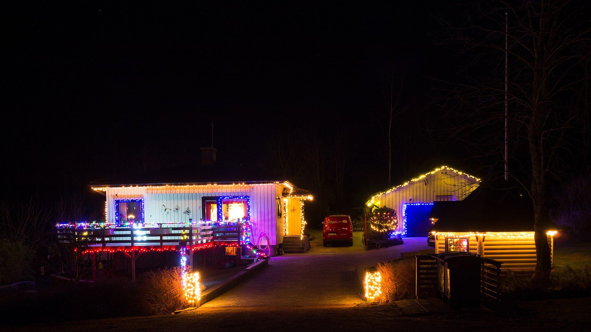 Homes with rooflines outlined in Christmas lights at night