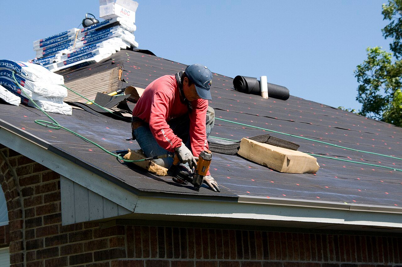 Worker on the edge of a house roof