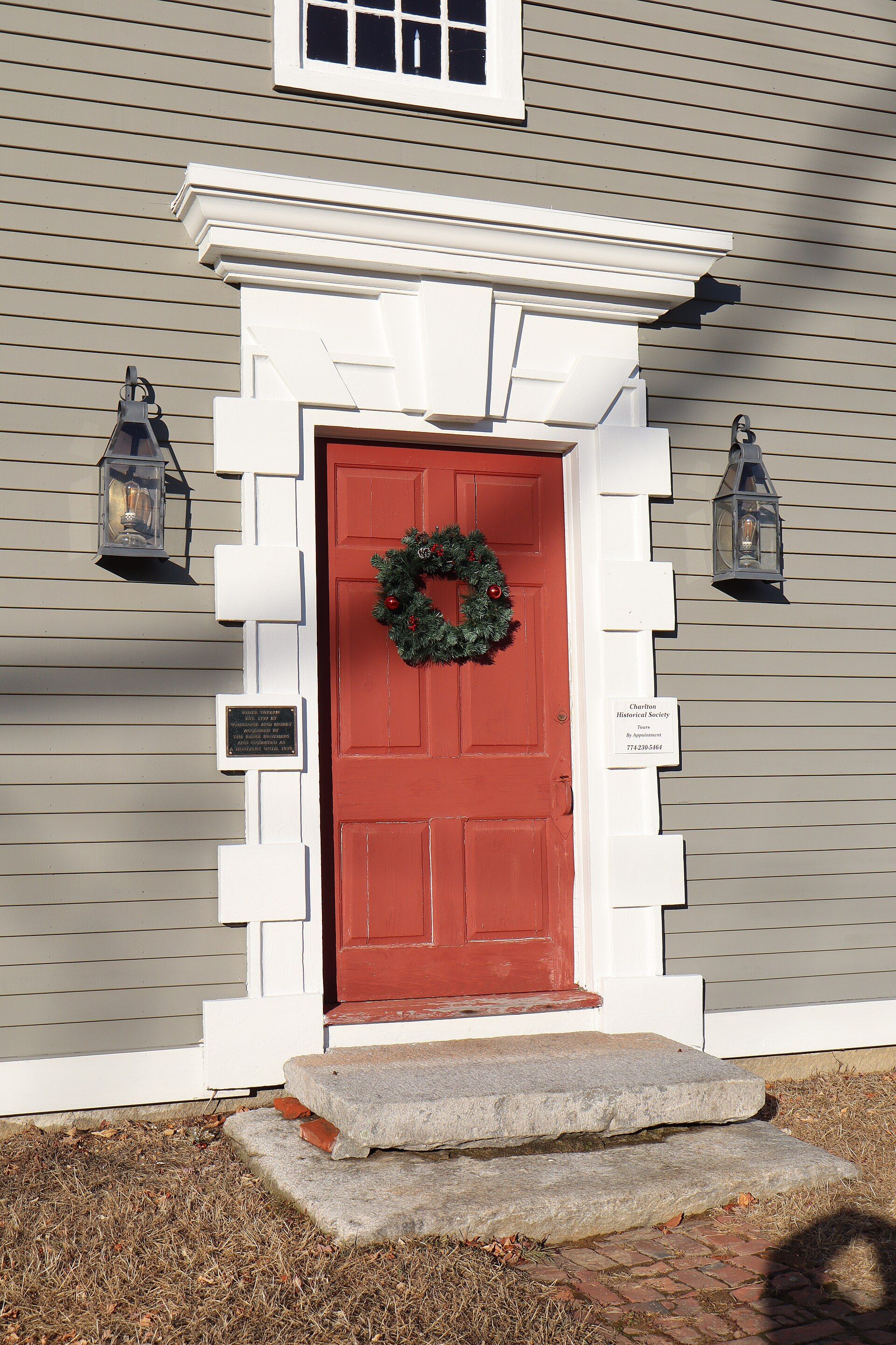Red front door with a Christmas wreath